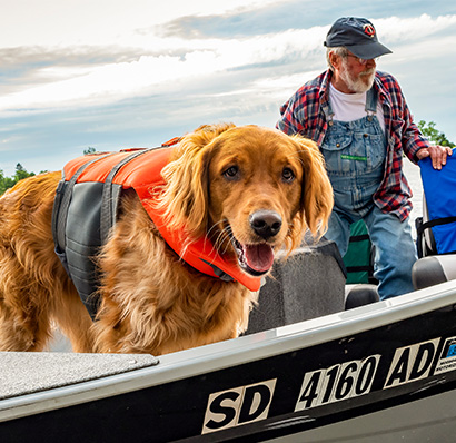 Old man in fishing boat with a dog