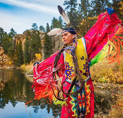 Native American woman in traditional attire dancing