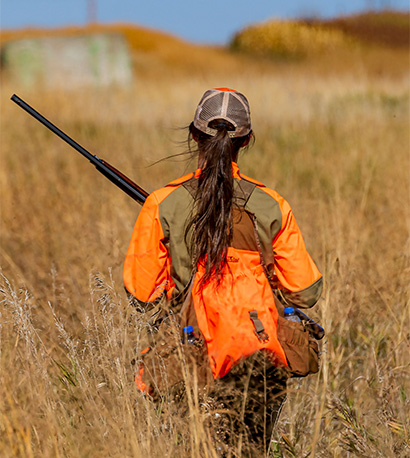 back of woman hunting in a field