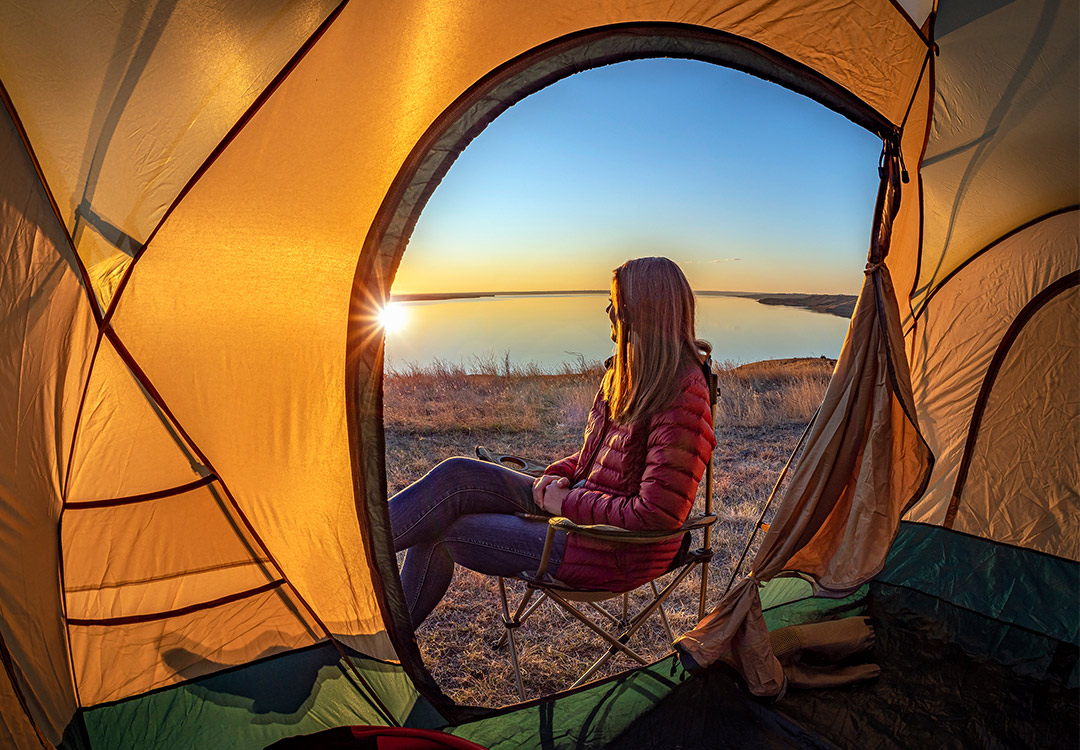 woman sitting in the mouth of tent