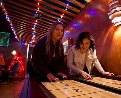 two girls playing shuffle board